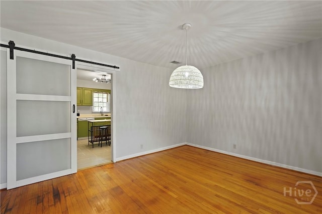 265 Mahan St, Jesup, GA 31545 - unfurnished dining area featuring light wood-type flooring and a barn door