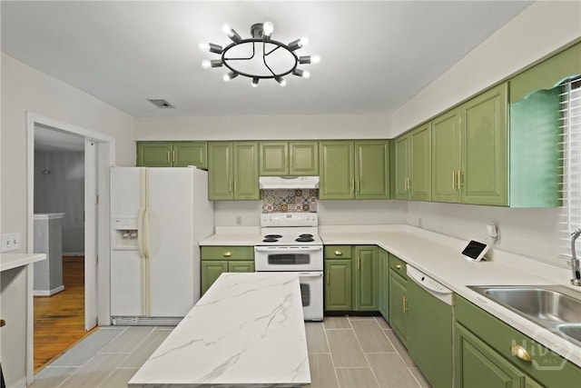 265 Mahan St, Jesup, GA 31545 - kitchen with white appliances, green cabinetry, under cabinet range hood, light stone countertops, and decorative backsplash