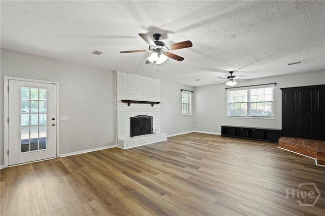 265 Mahan St, Jesup, GA 31545 - unfurnished living room with ceiling fan, wood finished floors, a textured ceiling, and a fireplace