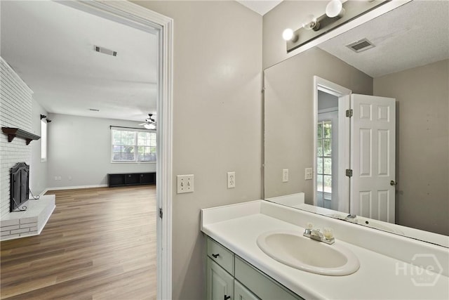 265 Mahan St, Jesup, GA 31545 - bathroom featuring wood finished floors, vanity, a fireplace, and ceiling fan