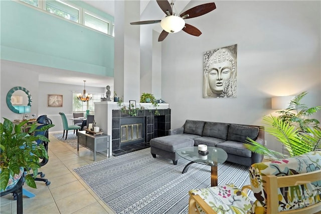 505 Pointe N Dr, Savannah, GA 31410 - living room with a high ceiling, light tile patterned floors, ceiling fan, a chandelier, and a tiled fireplace
