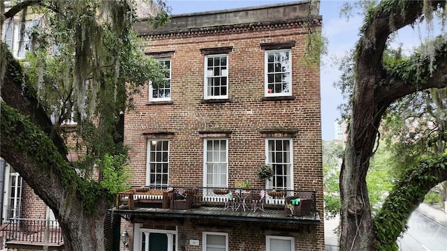 24 E Jones St, Savannah, GA 31401 - view of front of home featuring brick siding and a balcony
