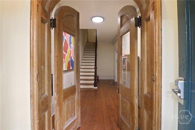 24 E Jones St, Savannah, GA 31401 - hallway featuring wood-type flooring, arched walkways, stairs, and ornamental molding
