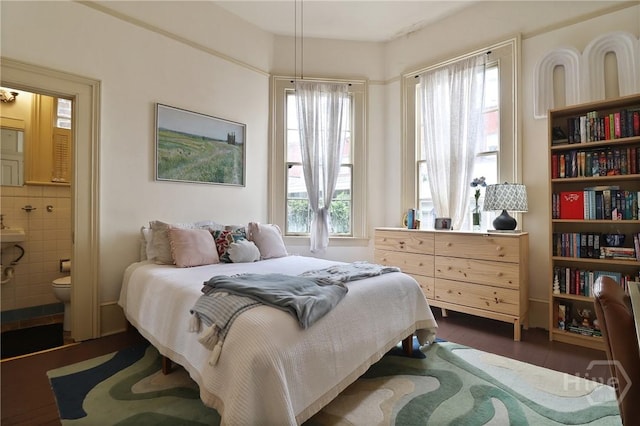24 E Jones St, Savannah, GA 31401 - bedroom featuring ensuite bathroom, dark wood-style flooring, and tile walls