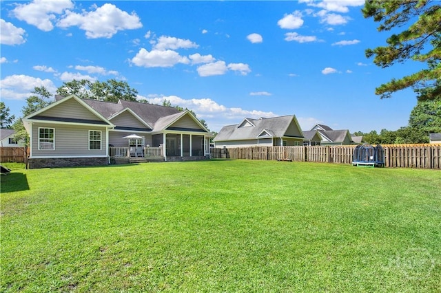 97 Misty Dr, Richmond Hill, GA 31324 - rear view of property with a trampoline, a sunroom, and a fenced backyard
