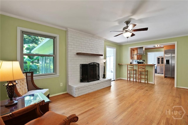 206 Devonshire Rd, Savannah, GA 31410 - living room featuring a ceiling fan, crown molding, light wood-style flooring, and a fireplace