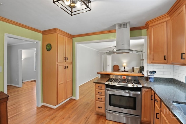 206 Devonshire Rd, Savannah, GA 31410 - kitchen with stainless steel range with gas stovetop, island range hood, ornamental molding, decorative backsplash, and light wood-style flooring