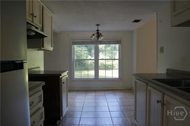 803 Jamestowne Rd, Savannah, GA 31419 - kitchen featuring freestanding refrigerator, extractor fan, a chandelier, dark countertops, and light tile patterned floors