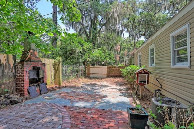 5513 Betty Dr, Savannah, GA 31406 - fenced backyard featuring an outdoor brick fireplace and a patio area