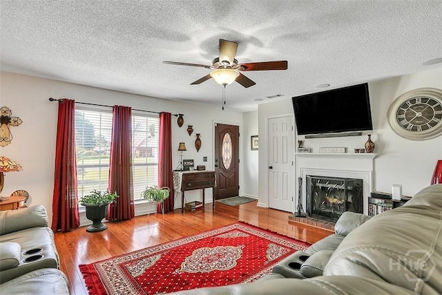 198 Jennifer Cir, Rincon, GA 31326 - living area with ceiling fan, a textured ceiling, wood finished floors, and a glass covered fireplace