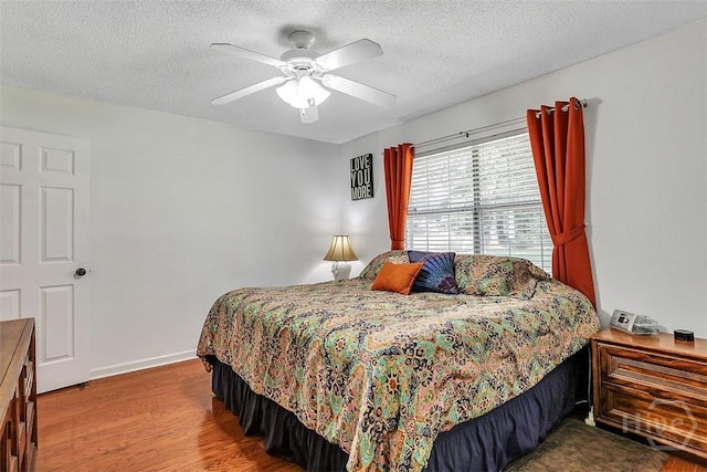 198 Jennifer Cir, Rincon, GA 31326 - bedroom with wood finished floors, a textured ceiling, and a ceiling fan