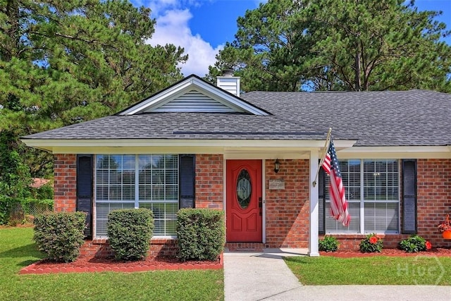 198 Jennifer Cir, Rincon, GA 31326 - view of front of property with brick siding, a shingled roof, a chimney, and a front lawn