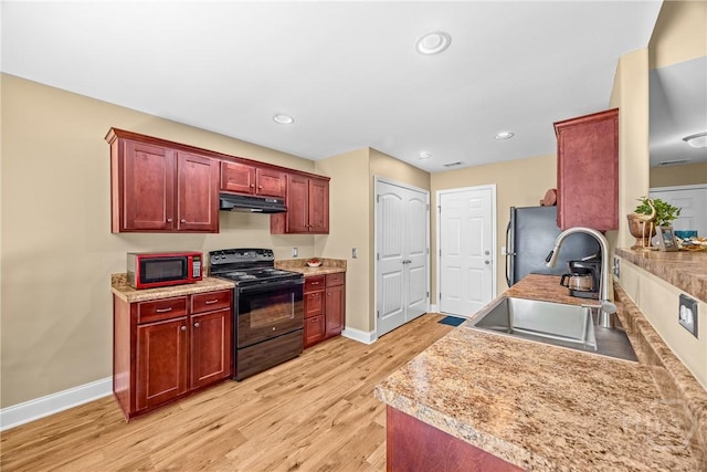 5 Winston Dr, Guyton, GA 31312 - kitchen with electric range, under cabinet range hood, dark brown cabinets, freestanding refrigerator, and light wood-style flooring