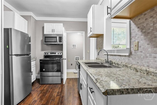1104 E 40th St, Savannah, GA 31404 - kitchen with appliances with stainless steel finishes, dark wood finished floors, backsplash, and white cabinets