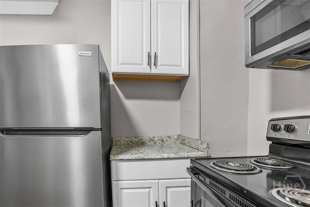 1104 E 40th St, Savannah, GA 31404 - kitchen featuring stainless steel appliances, white cabinets, and light stone countertops