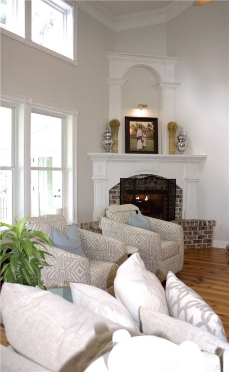 2766 Fort Mcallister Rd, Richmond Hill, GA 31324 - living area featuring a fireplace, a high ceiling, wood finished floors, and crown molding