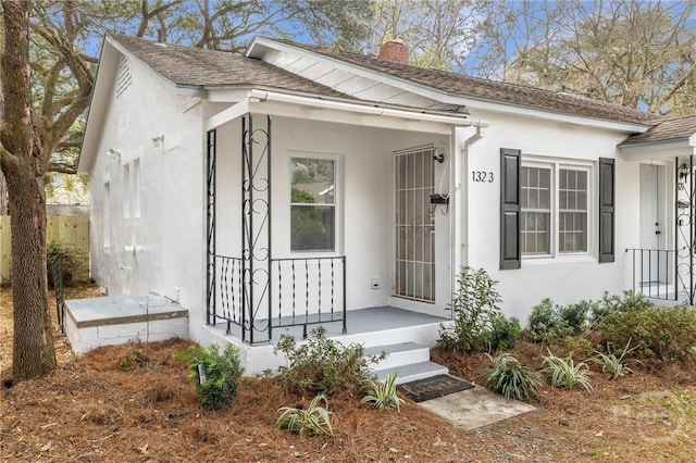 1321/1323 E 55th St, Savannah, GA 31404 - view of front facade with a chimney, stucco siding, and a shingled roof