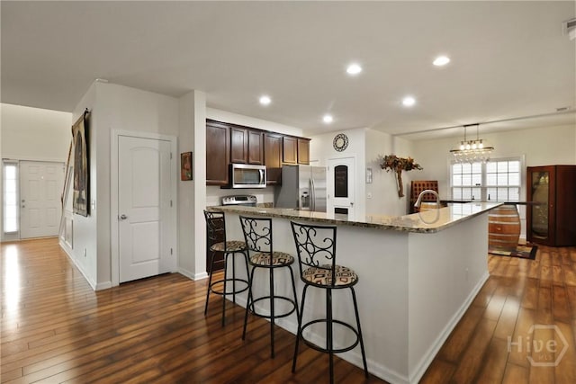 5 Olde Gate Ct, Pooler, GA 31322 - kitchen with stainless steel appliances, a breakfast bar, dark wood finished floors, a kitchen island, and dark stone countertops