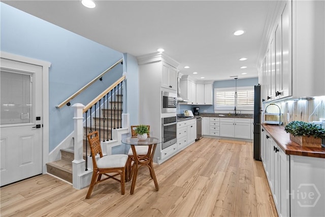 115 Coquena Cir E, Savannah, GA 31410 - kitchen with appliances with stainless steel finishes, light wood-type flooring, white cabinetry, recessed lighting, and wood counters