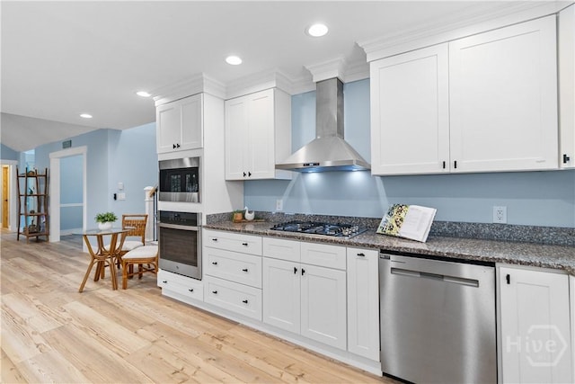 115 Coquena Cir E, Savannah, GA 31410 - kitchen with appliances with stainless steel finishes, wall chimney exhaust hood, light wood-type flooring, white cabinets, and recessed lighting