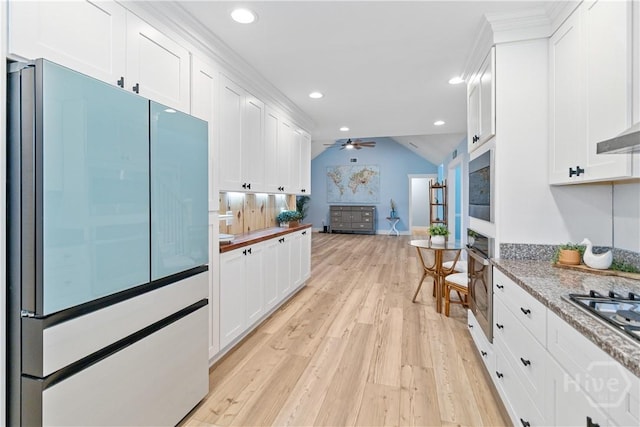 115 Coquena Cir E, Savannah, GA 31410 - kitchen with appliances with stainless steel finishes, light wood-style floors, white cabinetry, lofted ceiling, and recessed lighting
