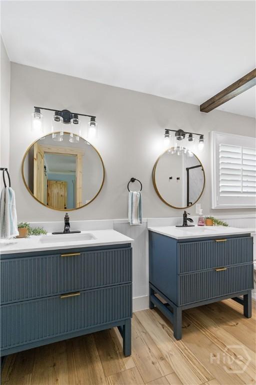 115 Coquena Cir E, Savannah, GA 31410 - bathroom with wood finished floors, two vanities, and beam ceiling