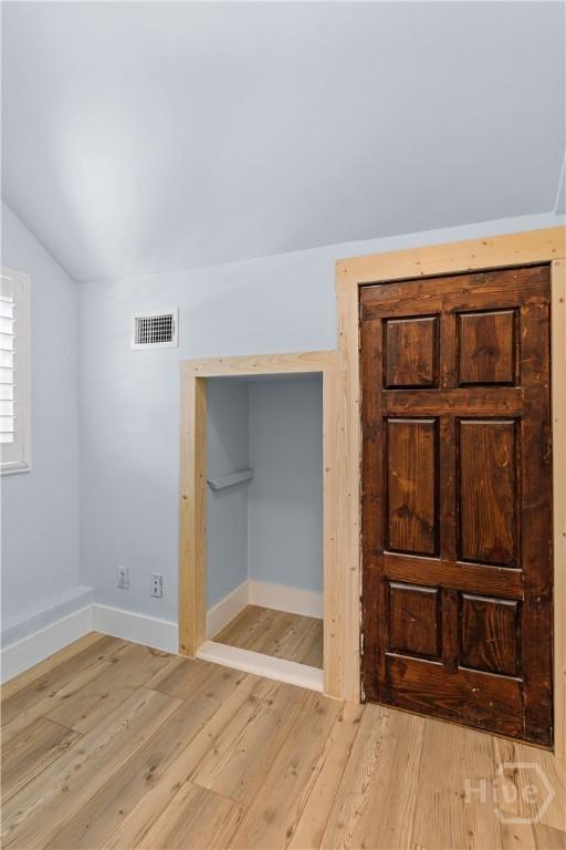 115 Coquena Cir E, Savannah, GA 31410 - unfurnished bedroom with lofted ceiling and light wood finished floors