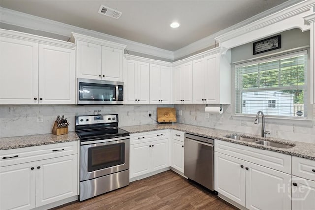 105 Summer Station Dr, Guyton, GA 31312 - kitchen with stainless steel appliances, crown molding, white cabinetry, tasteful backsplash, and light stone countertops