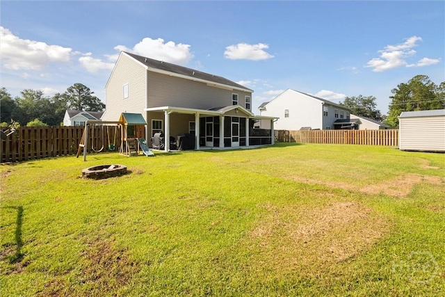 105 Summer Station Dr, Guyton, GA 31312 - back of property with a playground, a sunroom, a fenced backyard, and an outdoor fire pit