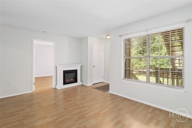 401 N Cromwell Rd Unit Q2, Savannah, GA 31410 - unfurnished living room with light wood-type flooring and a glass covered fireplace