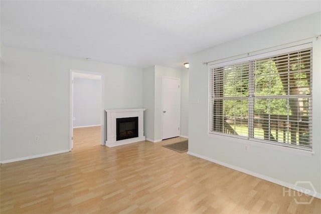 401 N Cromwell Rd Unit Q2, Savannah, GA 31410 - unfurnished living room with light wood finished floors, healthy amount of natural light, and a glass covered fireplace
