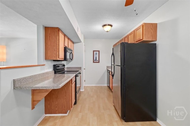 401 N Cromwell Rd Unit Q2, Savannah, GA 31410 - kitchen featuring black appliances, light wood finished floors, light countertops, a peninsula, and a ceiling fan