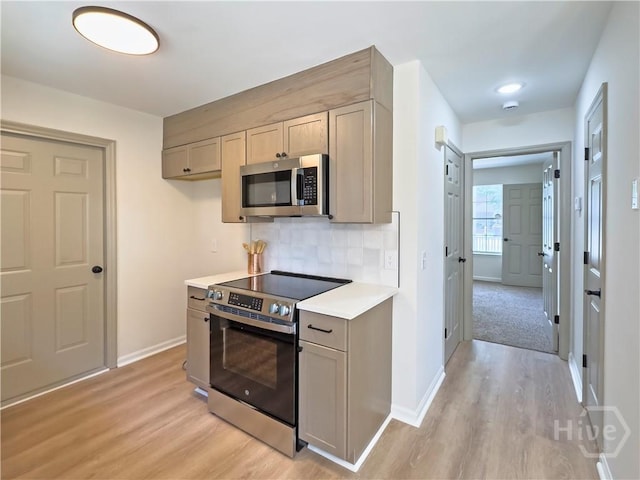 7231 Grant St, Savannah, GA 31406 - kitchen featuring stainless steel appliances, light wood-type flooring, light countertops, decorative backsplash, and gray cabinetry
