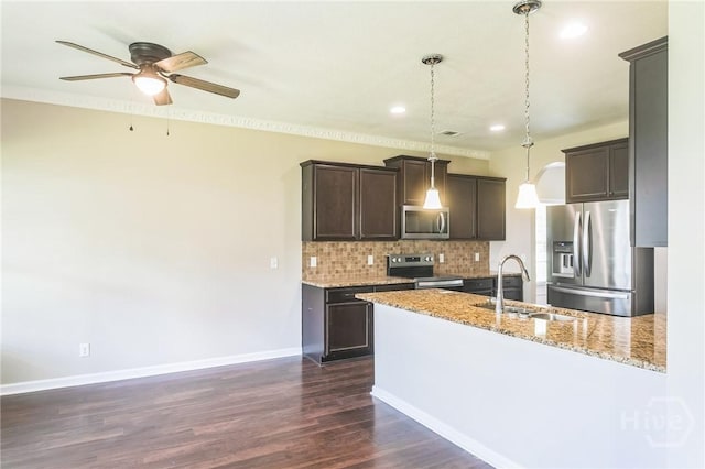 804 Barrington Dr, Hinesville, GA 31313 - kitchen featuring appliances with stainless steel finishes, dark brown cabinetry, backsplash, a peninsula, and light stone countertops