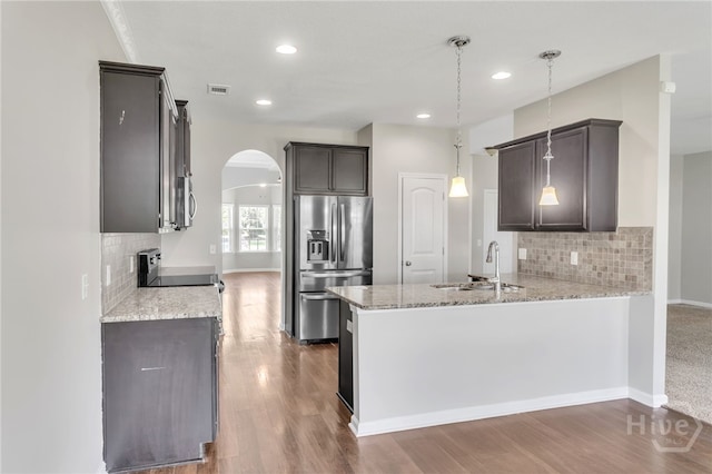 804 Barrington Dr, Hinesville, GA 31313 - kitchen featuring stainless steel refrigerator with ice dispenser, arched walkways, a peninsula, decorative backsplash, and recessed lighting