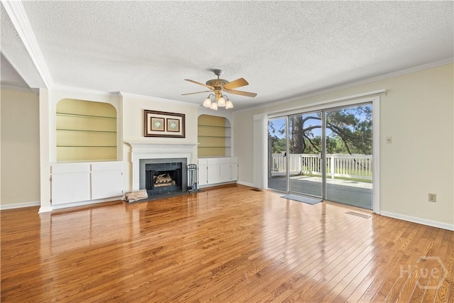 12502 Apache Ave Unit 18, Savannah, GA 31419 - unfurnished living room with a textured ceiling, hardwood / wood-style floors, crown molding, a ceiling fan, and built in features