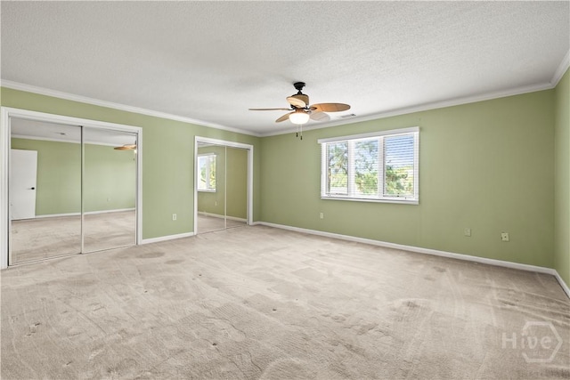 12502 Apache Ave Unit 18, Savannah, GA 31419 - unfurnished bedroom with ornamental molding, two closets, carpet flooring, a textured ceiling, and a ceiling fan