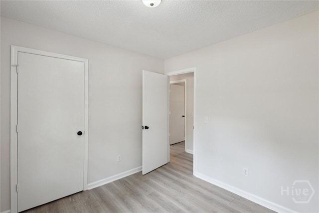 1021 Walnut Ct, Springfield, GA 31329 - unfurnished bedroom featuring light wood-style flooring, a textured ceiling, and a closet