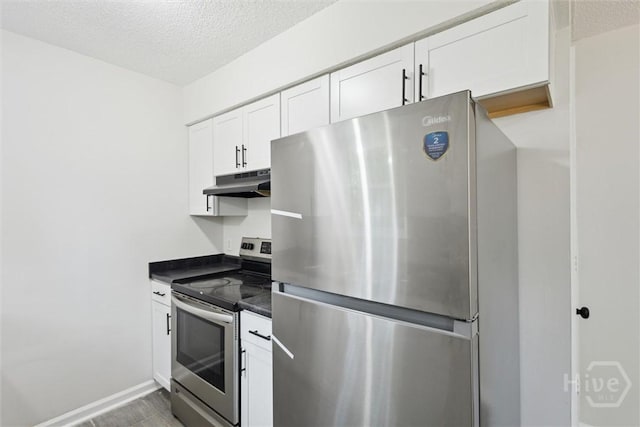 1021 Walnut Ct, Springfield, GA 31329 - kitchen with stainless steel appliances, under cabinet range hood, dark countertops, white cabinetry, and a textured ceiling