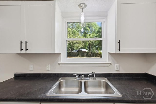 1021 Walnut Ct, Springfield, GA 31329 - kitchen featuring white cabinetry, dark countertops, pendant lighting, and a textured ceiling