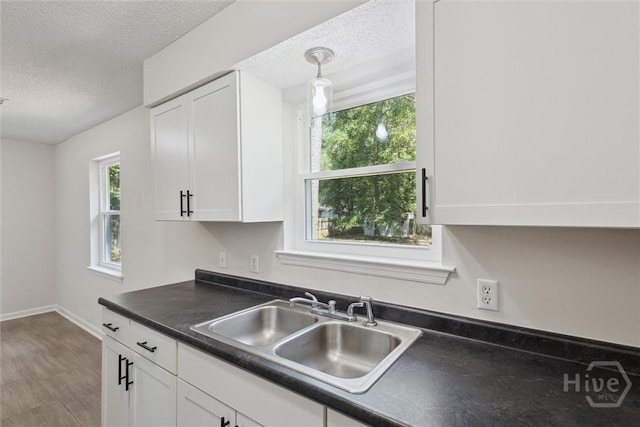 1021 Walnut Ct, Springfield, GA 31329 - kitchen with a textured ceiling, dark countertops, white cabinetry, and plenty of natural light