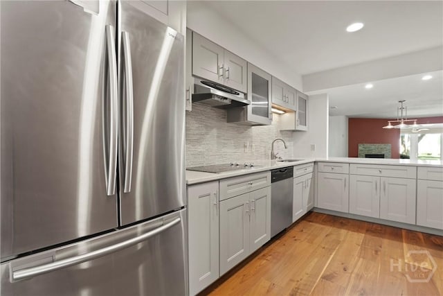 4 Tapestry Ln, Savannah, GA 31411 - kitchen with appliances with stainless steel finishes, under cabinet range hood, light countertops, decorative backsplash, and light wood-style flooring
