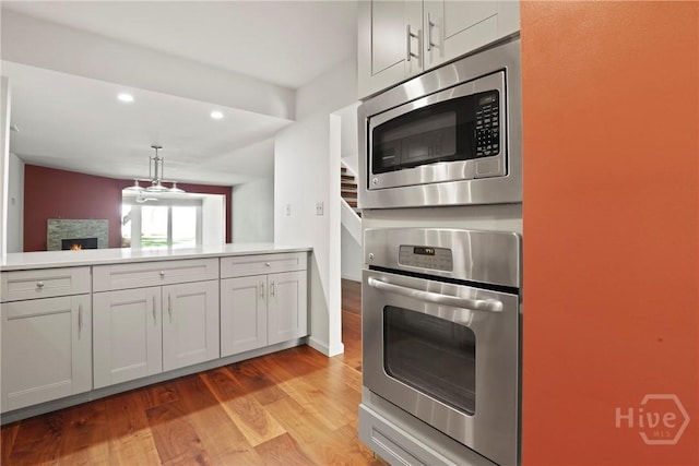 4 Tapestry Ln, Savannah, GA 31411 - kitchen featuring appliances with stainless steel finishes, light wood-type flooring, light countertops, recessed lighting, and hanging light fixtures