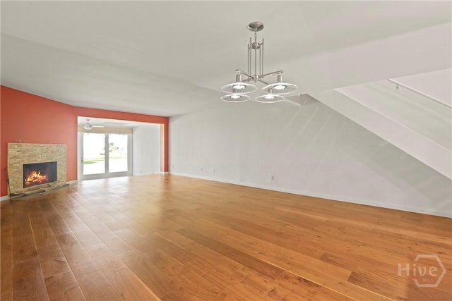 4 Tapestry Ln, Savannah, GA 31411 - unfurnished living room featuring hardwood / wood-style flooring, a stone fireplace, and a chandelier