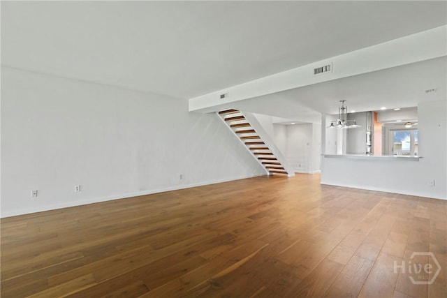 4 Tapestry Ln, Savannah, GA 31411 - unfurnished living room with hardwood / wood-style flooring, stairway, and a chandelier