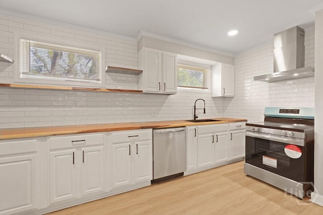 13 Hughes Ave, Savannah, GA 31406 - kitchen with stainless steel appliances, wall chimney range hood, ornamental molding, decorative backsplash, and light wood-type flooring