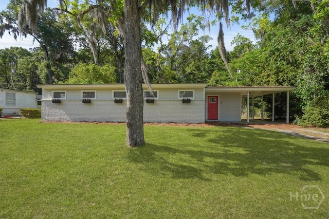 13 Hughes Ave, Savannah, GA 31406 - view of front of home with brick siding, a front lawn, an attached carport, and dirt driveway