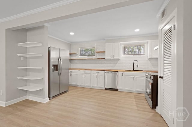 13 Hughes Ave, Savannah, GA 31406 - kitchen with appliances with stainless steel finishes, open shelves, ornamental molding, decorative backsplash, and light wood finished floors
