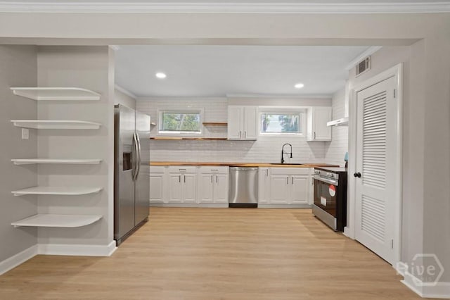 13 Hughes Ave, Savannah, GA 31406 - kitchen featuring appliances with stainless steel finishes, open shelves, white cabinets, light wood-type flooring, and healthy amount of natural light