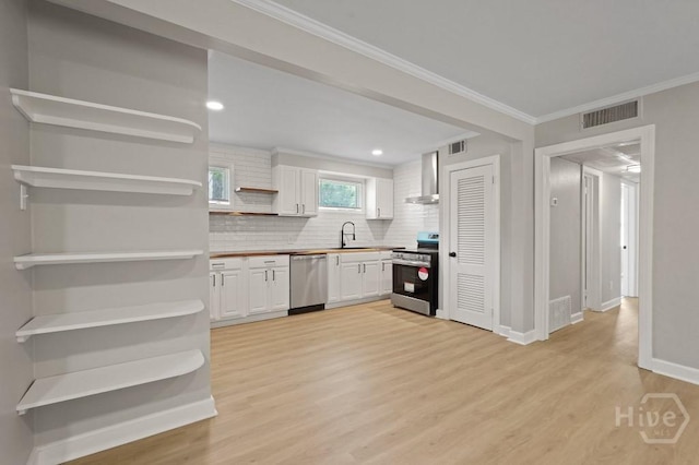 13 Hughes Ave, Savannah, GA 31406 - kitchen with appliances with stainless steel finishes, open shelves, wall chimney exhaust hood, light wood-style flooring, and white cabinets
